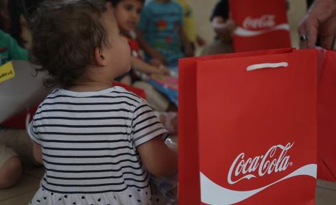 "المشروبات الوطنية" و "راية" توزعان الهدايا على الأطفال بالضفة