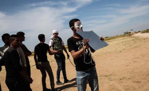 شاب يستخدم مرآة على حدود غزة للتشويش على قناصة جيش الاحتلال