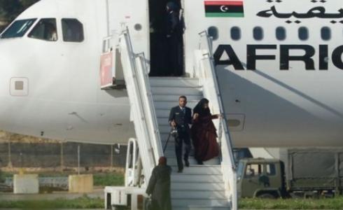 أحد أفراد طاقم الطائرة المختطفة وهو يساعد إحدى الراكبات لدى نزولها في مطار مالطا الدولي