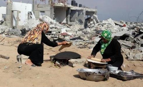 فلسطينيتان تعدان الخبز في العراء