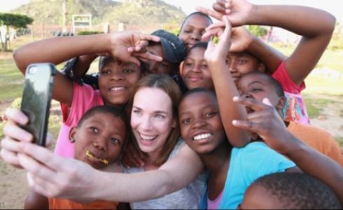 الممثلة لورا مين تلتقط صورة سيلفي بجانب أطفال في ليسوتو