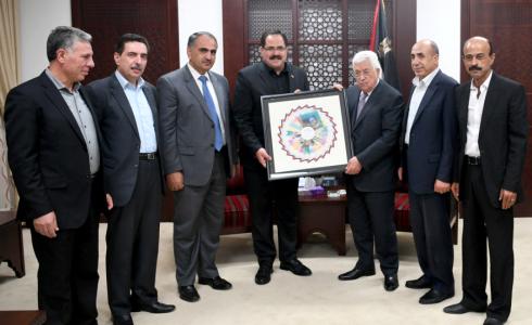 الرئيس، محمود عباس اثناء تسلمه النسخة الاولى للمناهج الدراسية(عدسة:أسامة فلاح)