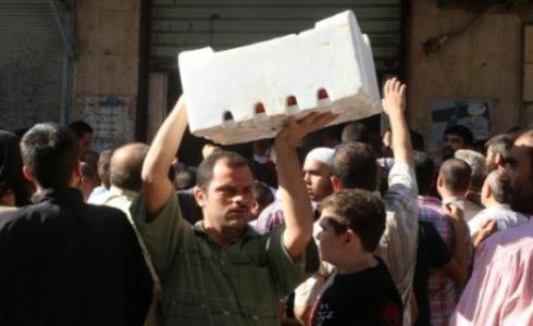 أحد سكان حلب يحمل صندوق معونات غذائية (رويترز)