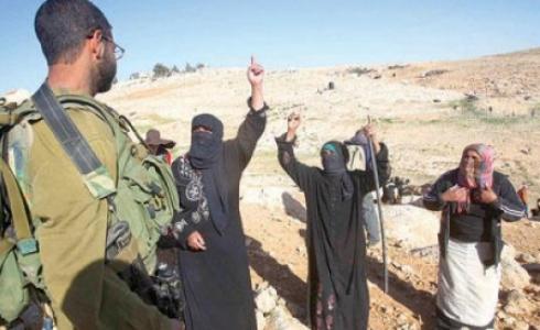 جندي اسرائيلي يقف أمام بدو فلسطينيون