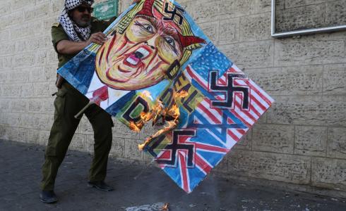 فلسطيني يحرق صور للرئيس الأمريكي دونالد ترامب في غزة 