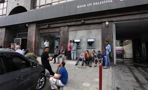 موظفون أمام بنك فلسطين في غزة ينتظرون صرف رواتبهم