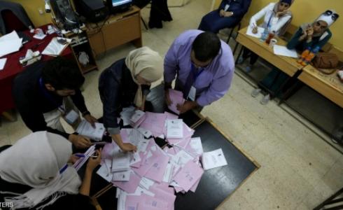 موظفون يحصون بطاقات الانتخاب في أحد مراكز الاقتراع في عمان
