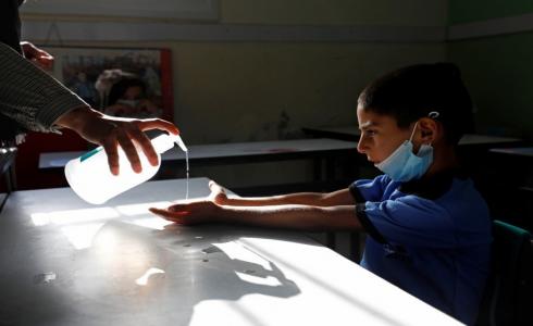 طالب فلسطيني يعقم يديه للحماية من فيروس كورونا