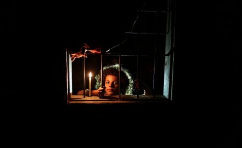 طفلة في غزة تضيء شمعة بسبب انقطاع الكهرباء جراء الحصار 