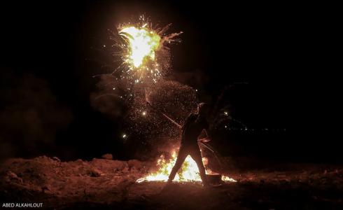 شاب يشارك في فعاليات مسيرة العودة ليلا في غزة -ارشيف-