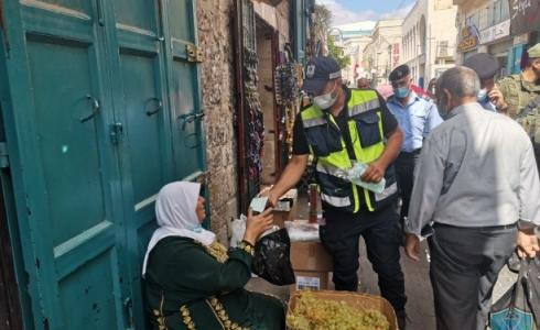أحد أفراد الشرطة يقوم بتوزيع الكمامات على المواطنين