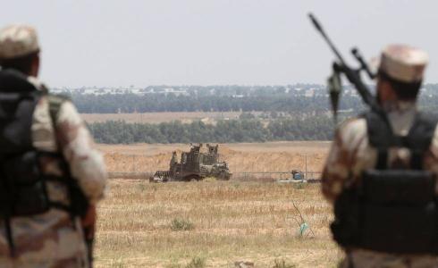 عناصر لحركة حماس يراقبون جرافات الاحتلال على حدود غزة