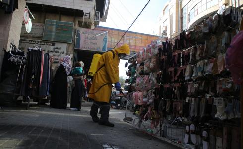 تعقيم المحال التجارية في مدينة الخليل بالضفة الغربية