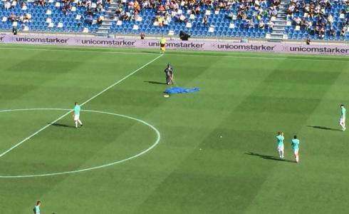 مشجع هبط بواسطة مظلة إلى أرض الملعب