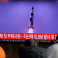 كوريون من كوريا الشمالية أثناء مشاهدتهم التجرية الصاروخية عبر شاشة عامة