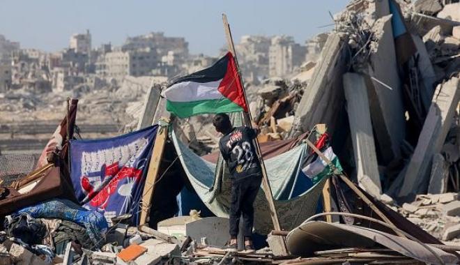 طفل يرفع علم فلسطين وسط الدمار في غزة - تعبيرية